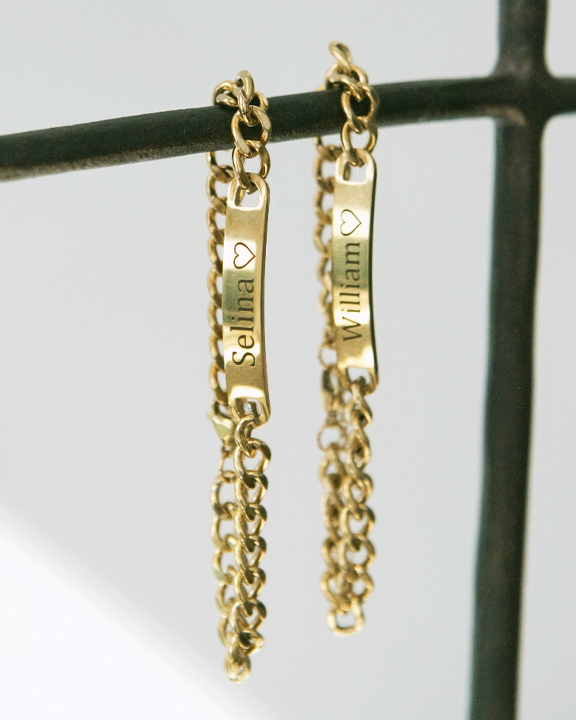 Couples Engraved Bracelet Set hanging from a bar